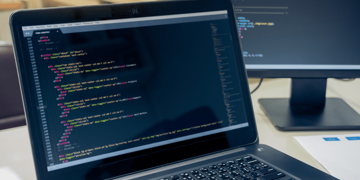 Laptop displaying code for web development, emphasizing programming and design for businesses in Dallas.